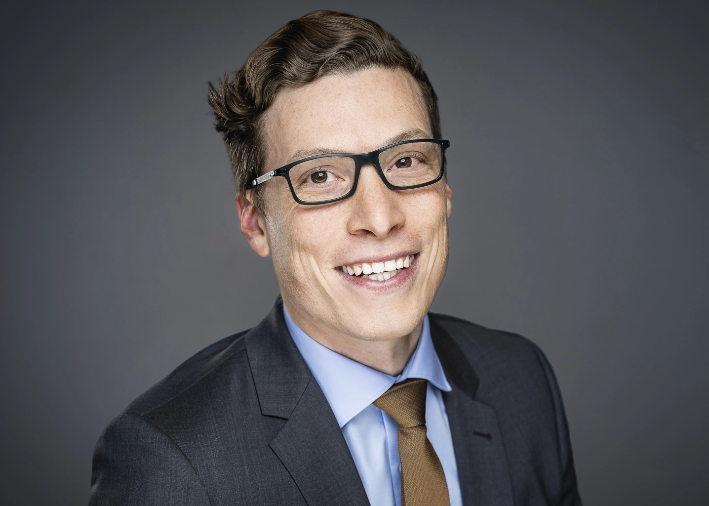 Studio Headshot of a Corporate Executive wearing glasses and a tie.